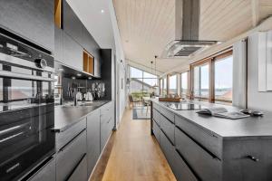 a kitchen with stainless steel counter tops and windows at 84164-Ronde-Stenhojvej-17 in Rønde