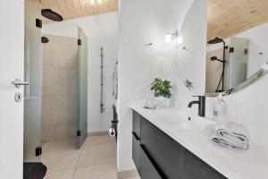a white bathroom with a sink and a shower at 84164-Ronde-Stenhojvej-17 in Rønde +14 photos