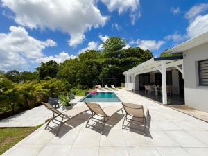 a patio with a table and chairs and a pool at La Villa Serenity Pool in Le Lamentin