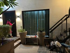 a person is standing outside a window with plants at Lumbini in Varanasi