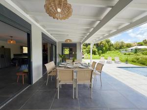 a dining room with a table and chairs on a patio at La Villa Serenity Pool in Le Lamentin