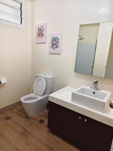 a bathroom with a toilet and a sink and a mirror at Pico hamilo coast condotel suite in Nasugbu