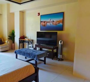 a bedroom with a bed and a tv and a couch at Pico hamilo coast condotel suite in Nasugbu
