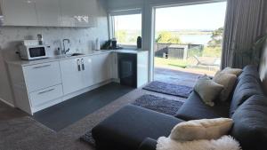 a living room with a couch and a kitchen at Riverside Retreat with River views in Auckland