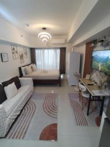 a living room with a couch and a table and a television at Spacious Studio Davao in Davao City
