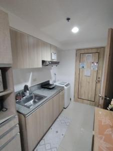 a small kitchen with a sink and a refrigerator at Spacious Studio Davao in Davao City