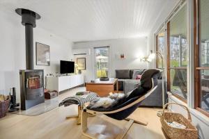 a living room with a chair and a couch at 84230-Ebeltoft-Skovduevej-10 in Ebeltoft