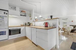 a kitchen with white cabinets and a counter top at 84230-Ebeltoft-Skovduevej-10 in Ebeltoft +15 photos