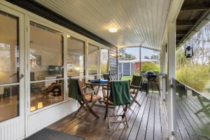 a screened in porch with a table and chairs at 84230-Ebeltoft-Skovduevej-10 in Ebeltoft