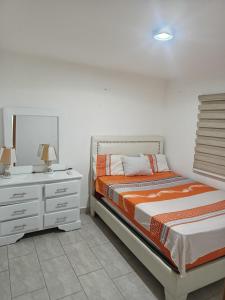 a bedroom with a bed and a dresser with a mirror at Vista Colonial, en el Residencial Riviera Colonial in Calero