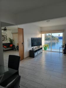 a living room with a large screen tv and a couch at Vista Colonial, en el Residencial Riviera Colonial in Calero