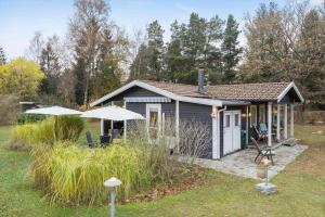a small shed with an umbrella in a yard at 84230-Ebeltoft-Skovduevej-10 in Ebeltoft