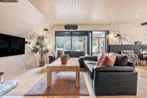 a living room with a couch and a table at 84109-Ebeltoft-Birkevej-1 in Øksenmølle