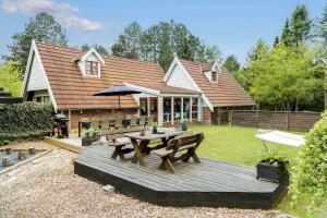 a backyard with a picnic table and an umbrella at 84109-Ebeltoft-Birkevej-1 in Øksenmølle