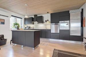 a kitchen with black cabinets and stainless steel appliances at 84231-Ebeltoft-Magevej-50 in Ebeltoft