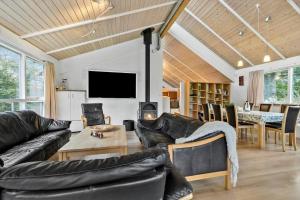 a living room with black leather furniture and a table at 84218-Ebeltoft-Koravej-21 in Ebeltoft