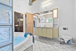 a bathroom with a tub and a toilet and a sink at 84218-Ebeltoft-Koravej-21 in Ebeltoft +14 photos