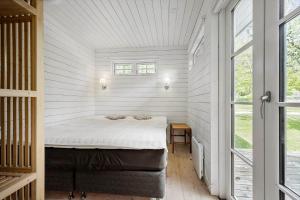 a bedroom with a bed in a white room at 8242-Knebel-Uraniavej-5 in Knebel
