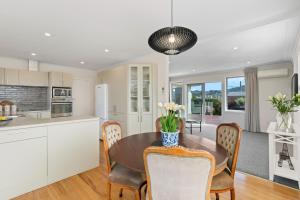 a kitchen and dining room with a table and chairs at Roslyn Sanctuary Hereford St Dunedin in Dunedin