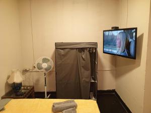 a room with a tv on a wall with a bed at Lima Centro Guest House Barrios in Lima