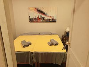 a bedroom with a yellow bed with two slippers on it at Lima Centro Guest House Barrios in Lima +16 photos