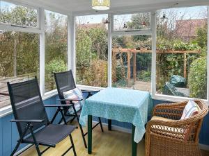 a screened in porch with a table and chairs at The Castaway in Mundesley +13 photos