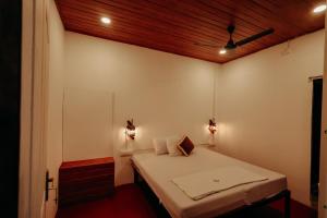 a small room with a bed with two lamps at Marari Jackson Beach Homestay in Mararikulam +24 photos