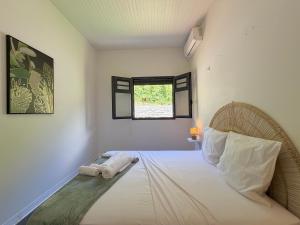 a bedroom with a bed with two towels on it at La Villa Serenity Pool in Le Lamentin +26 photos