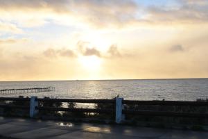 a sunset over the ocean with a fence at Morada Austral in Punta Arenas