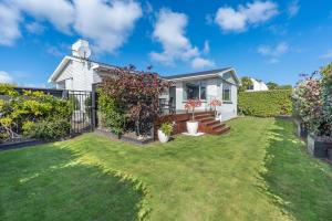 a small white house with a yard at Roslyn Sanctuary Hereford St Dunedin in Dunedin
