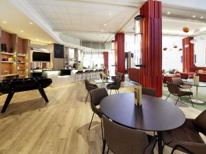 a living room with a pool table and chairs at Novotel Clermont-Ferrand in Clermont-Ferrand