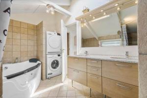 a bathroom with a washing machine and a washer and dryer at 84252-Ronde-Folfodvej-16 in Rønde +23 photos