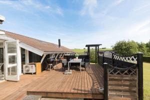 a wooden deck with a table and chairs on it at 84252-Ronde-Folfodvej-16 in Rønde