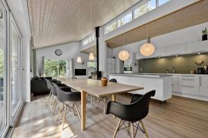 a kitchen and dining room with a wooden table and chairs at 84264-Ronde-Enebaervej-4 in Rønde