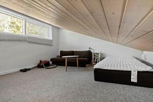 a bedroom with a bed and a couch at 84264-Ronde-Enebaervej-4 in Rønde