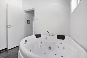 a large white bath tub in a bathroom at 84264-Ronde-Enebaervej-4 in Rønde +18 photos