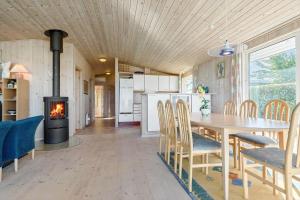 a kitchen and dining room with a table and a fireplace at 84266-Knebel-Toplaerkevej-1 in Knebel +25 photos