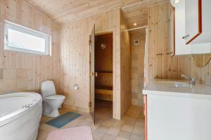 a bathroom with a toilet and a sink and a tub at 84266-Knebel-Toplaerkevej-1 in Knebel