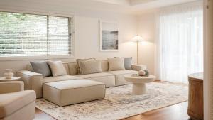 a living room with a couch and a table at Gemburra By Holidayco in Pearl Beach