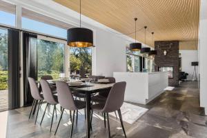 a dining room with a black table and chairs at 8244-Knebel-Metholmvej-20 in Knebel