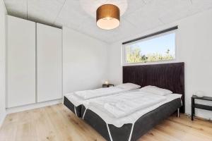 a bedroom with a bed and a large window at 8244-Knebel-Metholmvej-20 in Knebel
