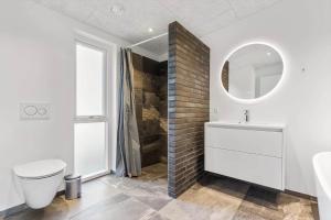 a bathroom with a sink and a toilet and a mirror at 8244-Knebel-Metholmvej-20 in Knebel