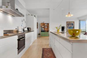 a kitchen with white cabinets and a yellow bowl on the counter at 84281-Ebeltoft-Hvide-Hus-Vej-3 in Ebeltoft +14 photos