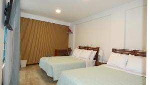 a hotel room with two beds with white sheets at MAKEYA Home-Hotel in Churín
