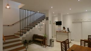 a woman sitting at a counter in a room with a staircase at MAKEYA Home-Hotel in Churín