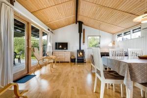 a dining room with a table and chairs and a tv at 30512-Odder-Hasselvaenget-9 in Odder