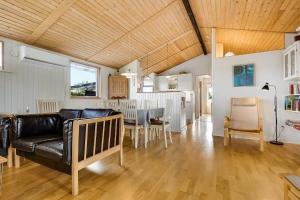 a living room with a black leather couch and a table at 30512-Odder-Hasselvaenget-9 in Odder