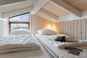 two beds in a room with white sheets and a window at 30430-Odder-Strandvaenget-15 in Odder