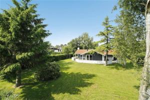 a house in the middle of a yard with trees at 30410-Odder-Hulager-2 in Odder