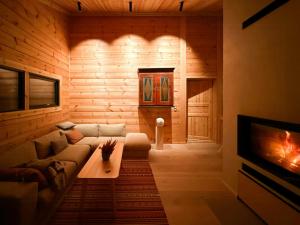 a living room with a couch and a fireplace at Architect-Designed Log Cabin By Myllavannet in Lunner